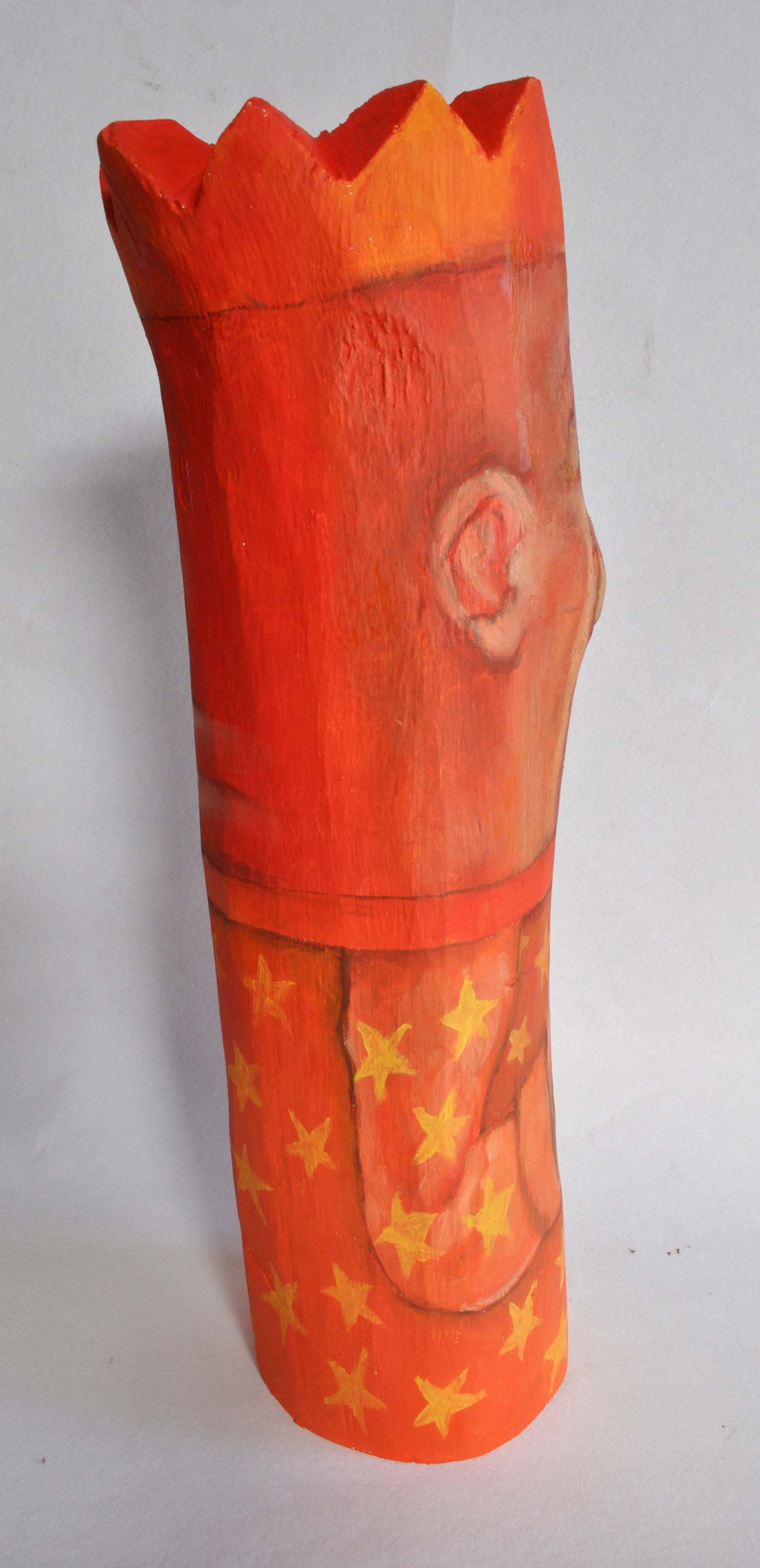 Peint sur une bûche de chêne, dans des tons rouge vifs, un roi. Le visage occupe presque la moitié de la hauteur, triste, avec un gros nez. Il porte une main sur son coeur. Sa tunique est constellée d'étoiles oranges. Les seules parties sculptées sont le dessous de son nez et les pointes de sa couronne.